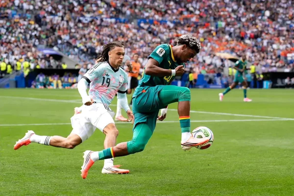Cameroon player dribbling past opponent during match Cameroon player dribbling past opponent during match