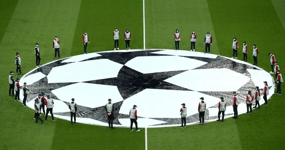 Ground staff preparing UEFA Champions League logo on pitch Ground staff preparing UEFA Champions League logo on pitch