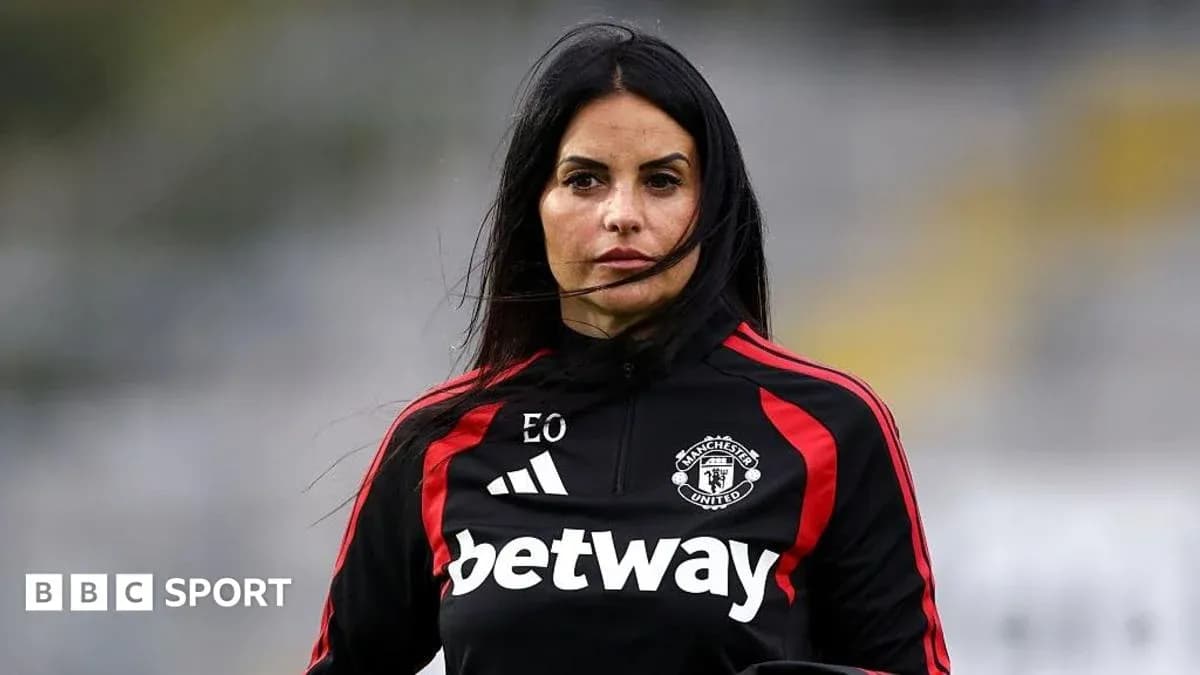 Coach wearing Manchester United tracksuit on pitch Coach wearing Manchester United tracksuit on pitch