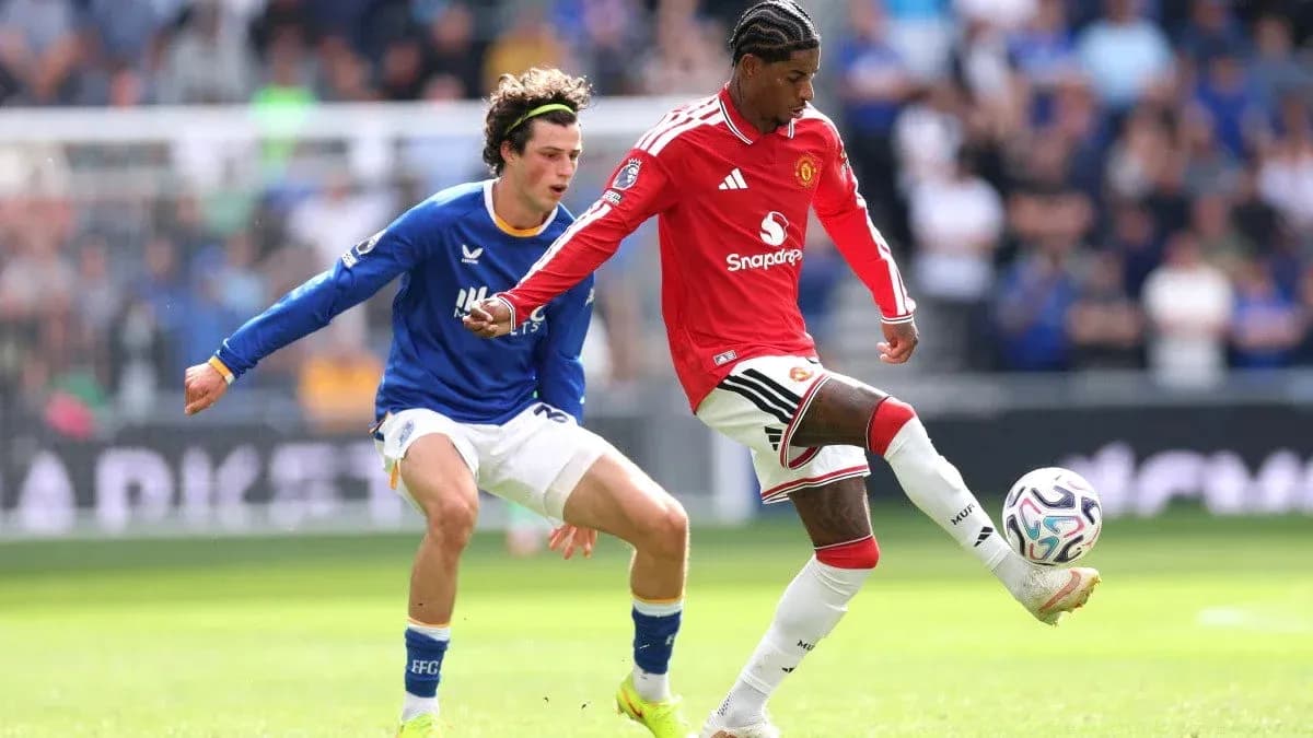 Manchester United player dribbling past opponent Manchester United player dribbling past opponent