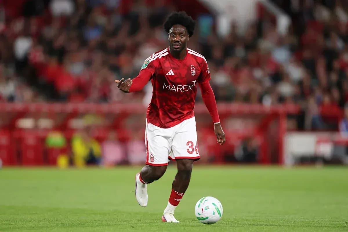 Player in red kit directing play on field Player in red kit directing play on field