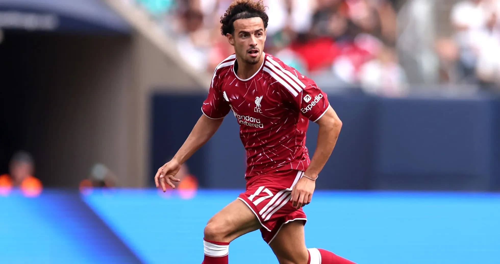 Player in red Liverpool kit running on the pitch Player in red Liverpool kit running on the pitch