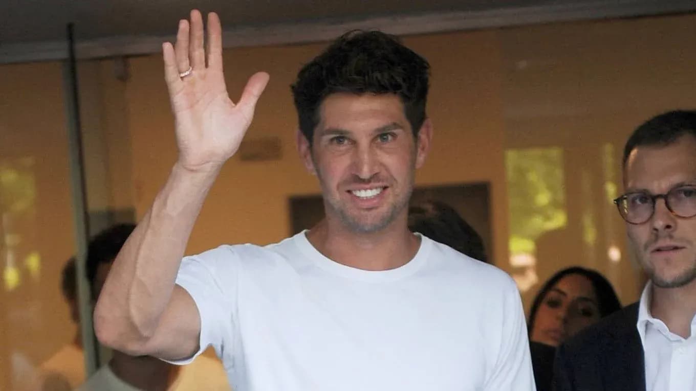 Man waving while wearing a white shirt Man waving while wearing a white shirt