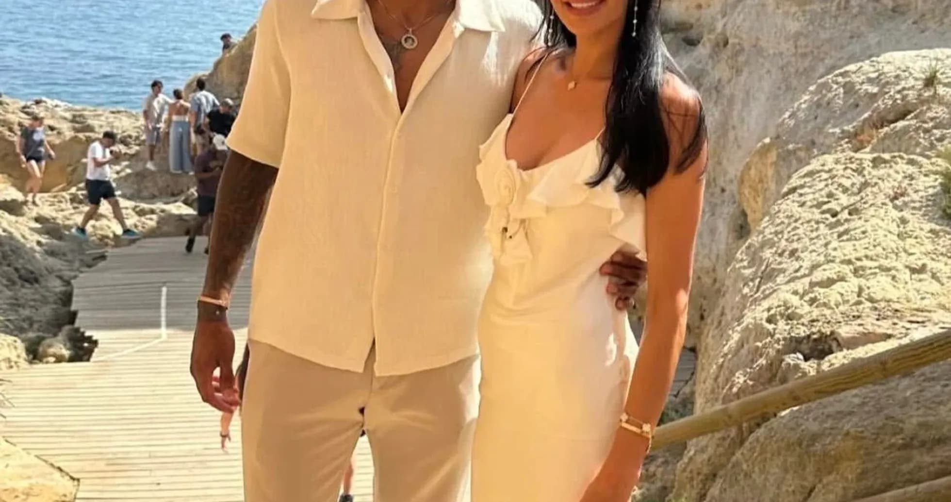 Couple posing together near rocky coastline Couple posing together near rocky coastline