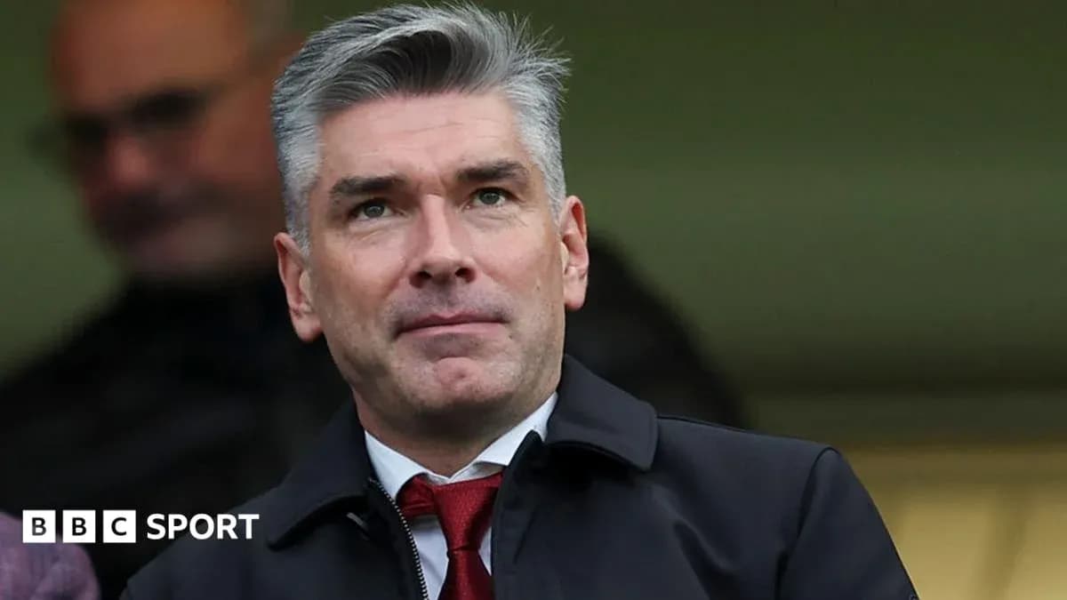 Man in suit observing from the stands at a match Man in suit observing from the stands at a match