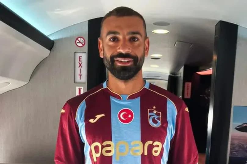 Player wearing Trabzonspor jersey in airplane aisle Player wearing Trabzonspor jersey in airplane aisle