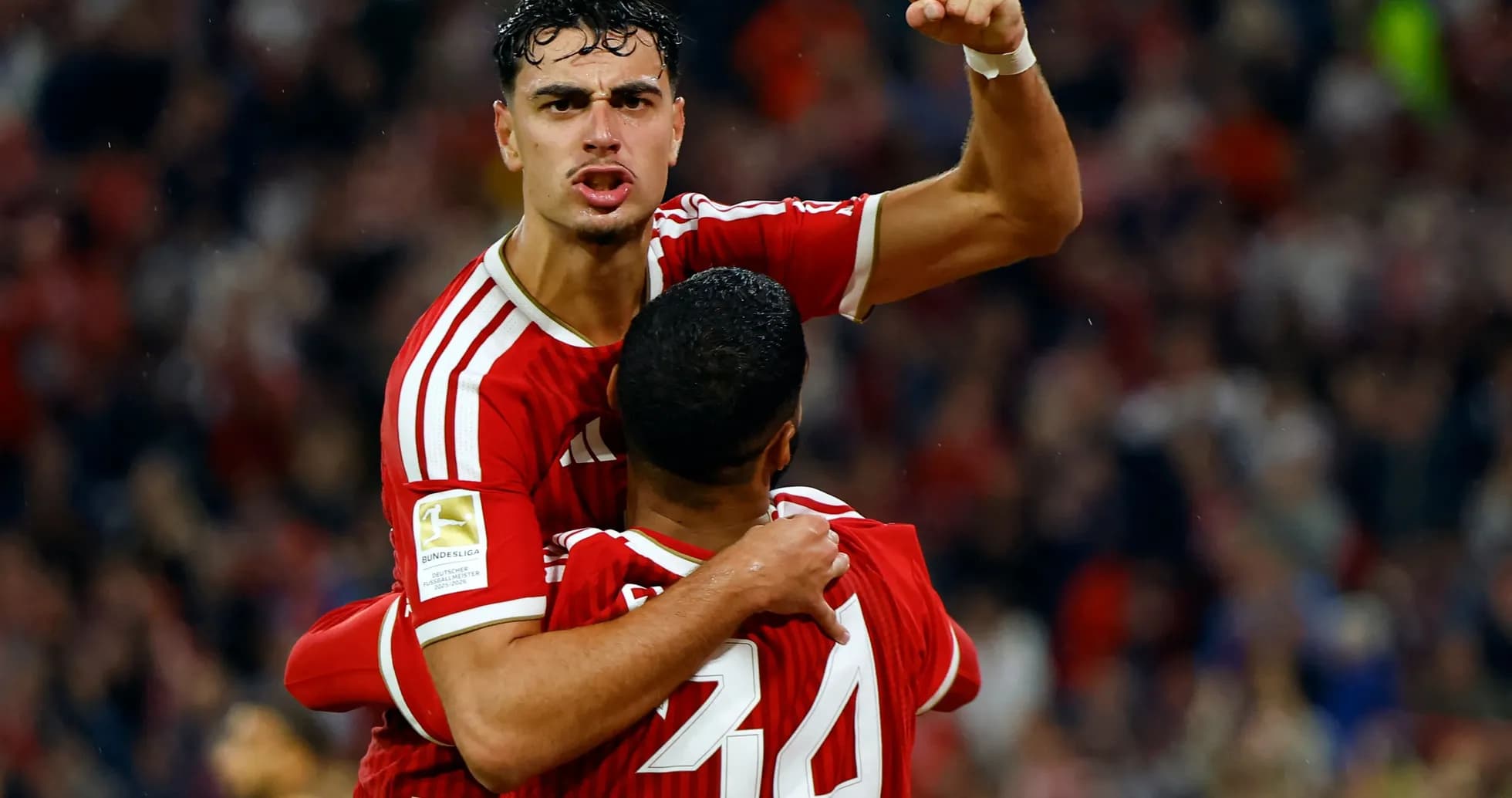 Player celebrating goal with teammate on the pitch Player celebrating goal with teammate on the pitch