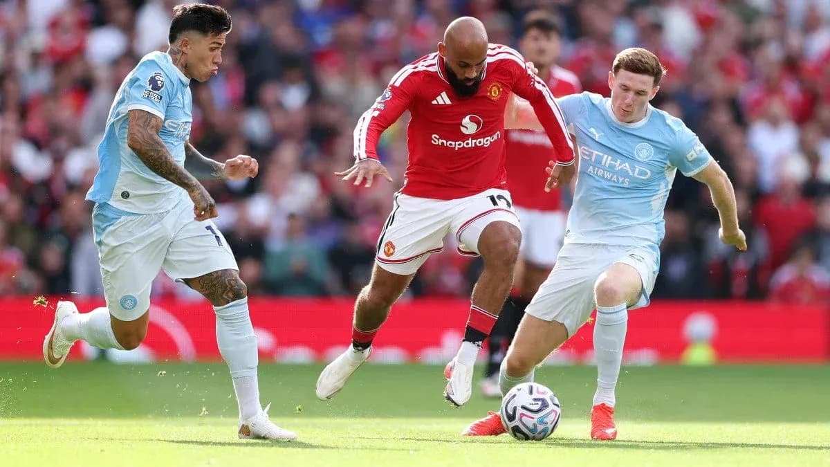 Players from Manchester United and Manchester City competing for the ball Players from Manchester United and Manchester City competing for the ball