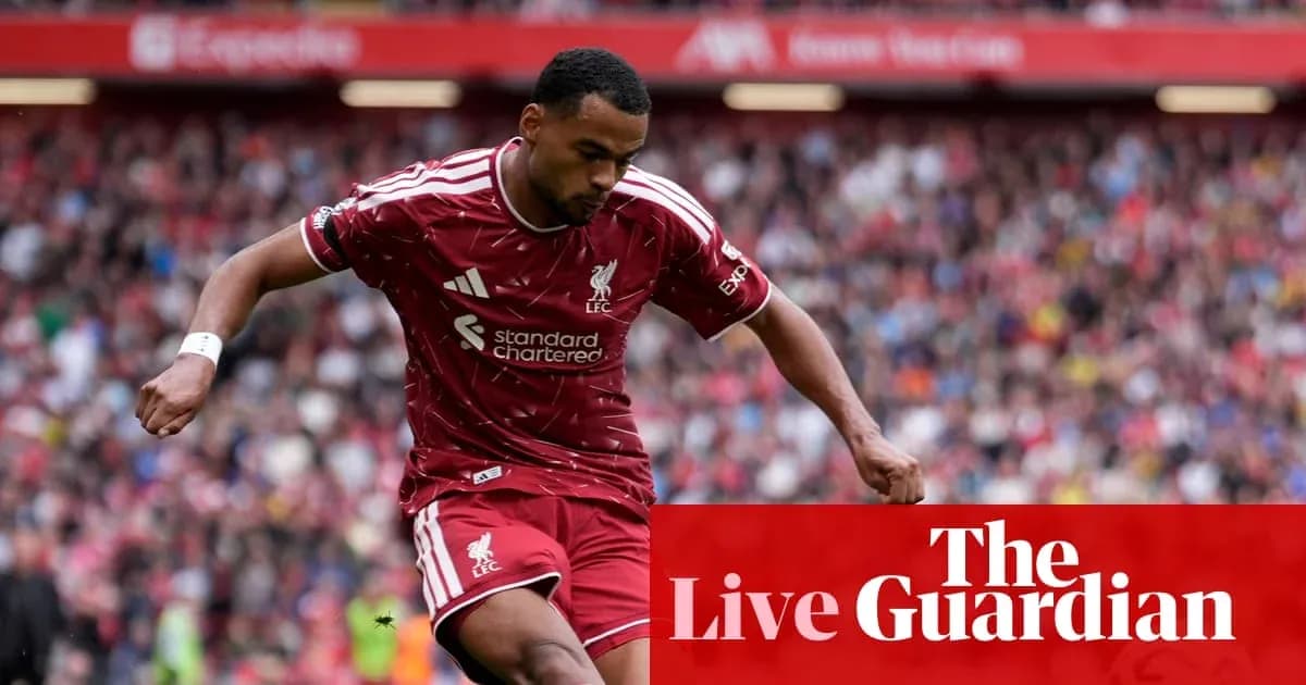 Liverpool player dribbling during match at Anfield Liverpool player dribbling during match at Anfield