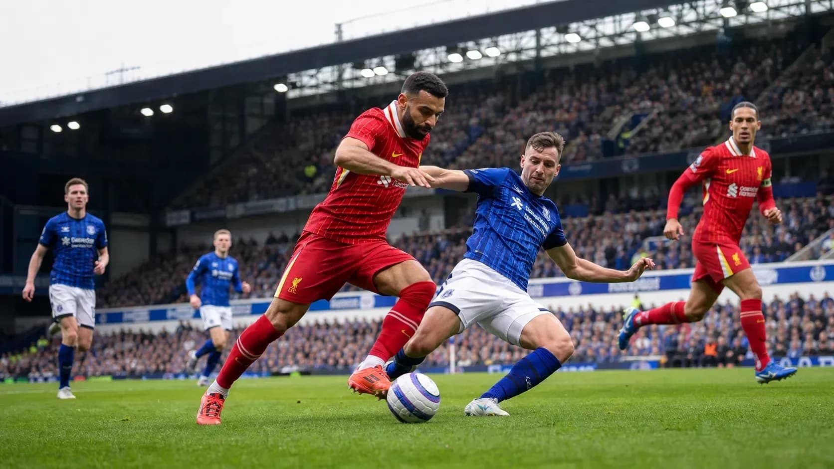 Liverpool and Everton players contesting for the ball Liverpool and Everton players contesting for the ball