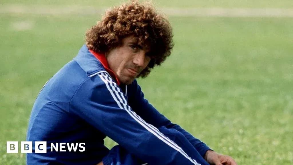 Football player sitting on grass field in tracksuit Football player sitting on grass field in tracksuit