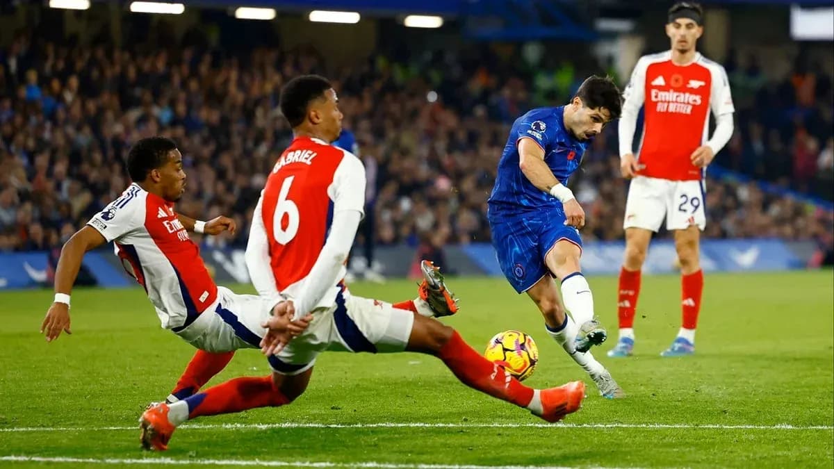 Chelsea player shooting while Arsenal defenders attempt to block Chelsea player shooting while Arsenal defenders attempt to block