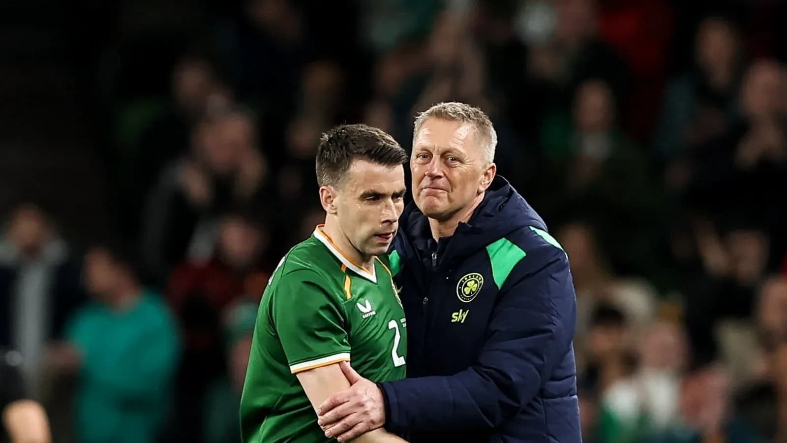 Player receiving support from coach after substitution Player receiving support from coach after substitution