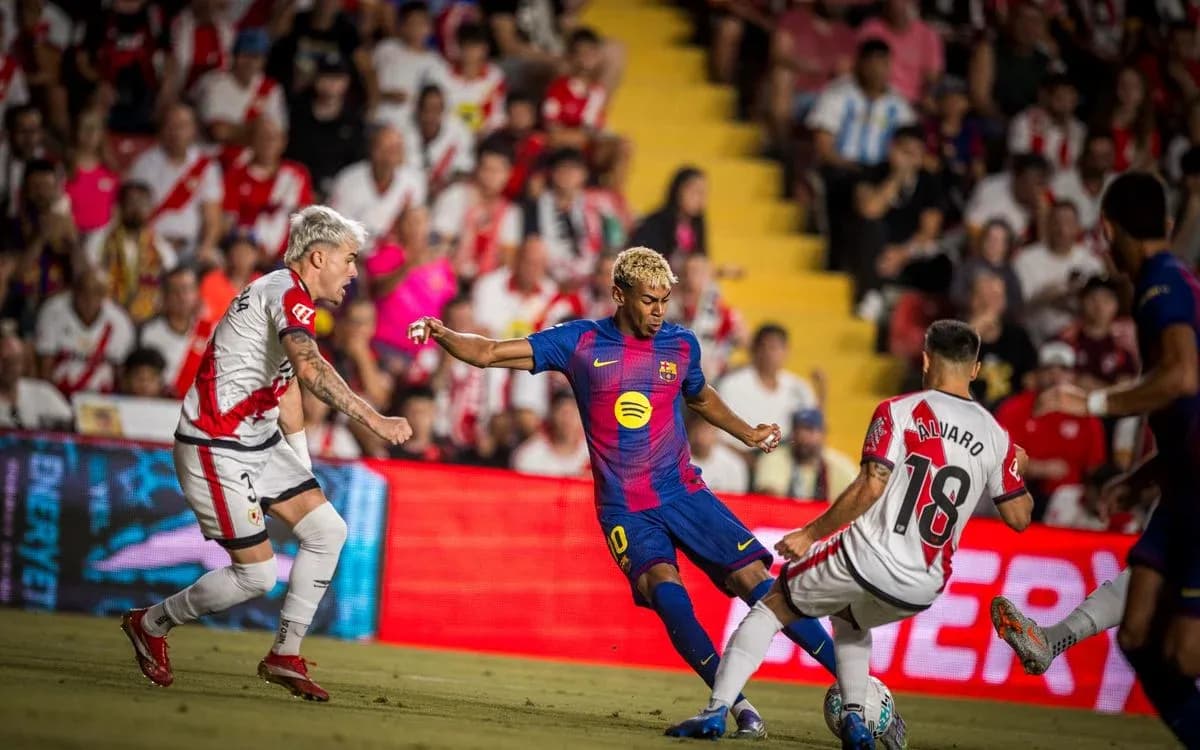 Barcelona player dribbling past Rayo Vallecano defenders Barcelona player dribbling past Rayo Vallecano defenders