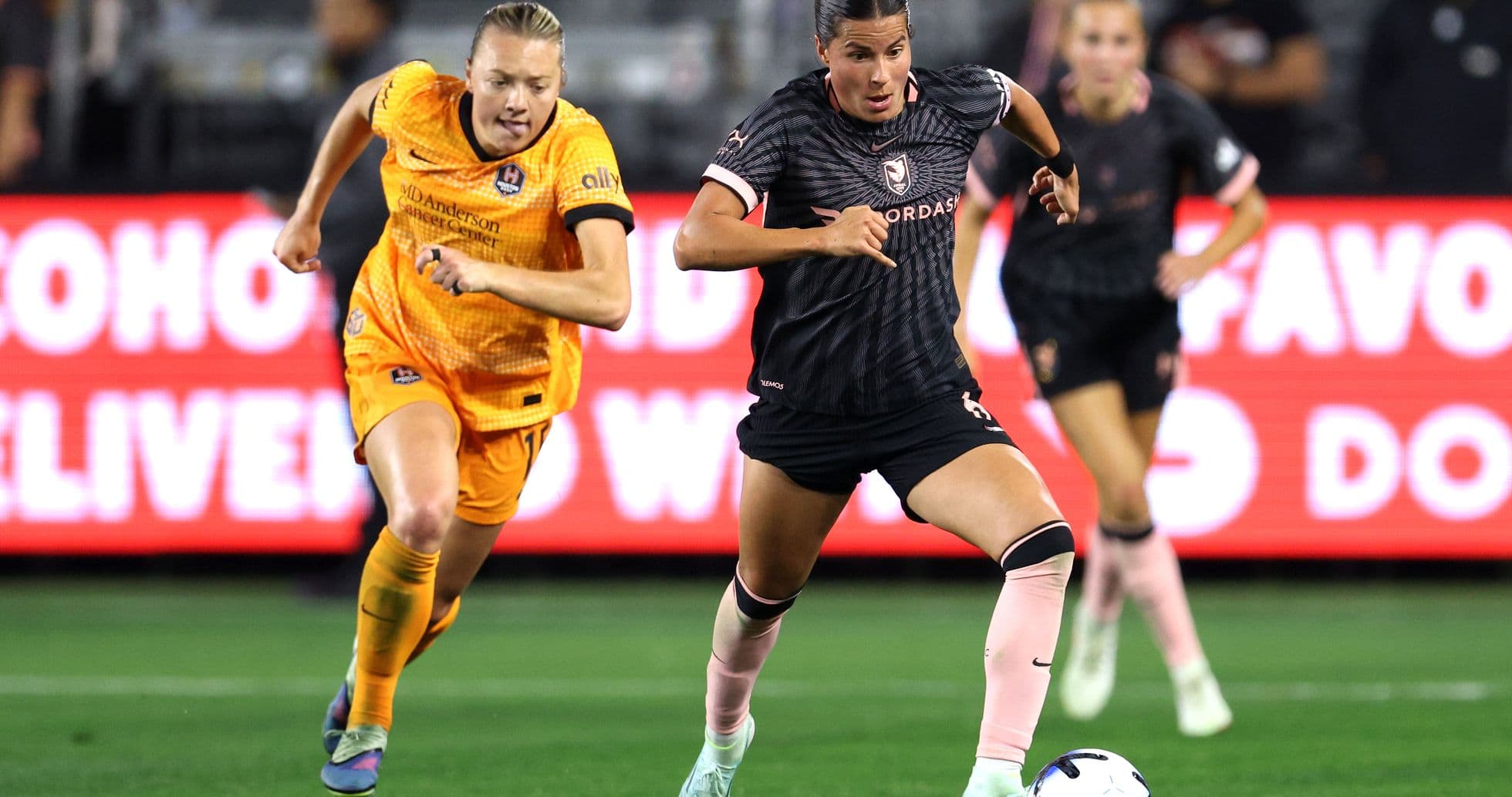 Houston Dash player dribbling past Angel City opponent Houston Dash player dribbling past Angel City opponent