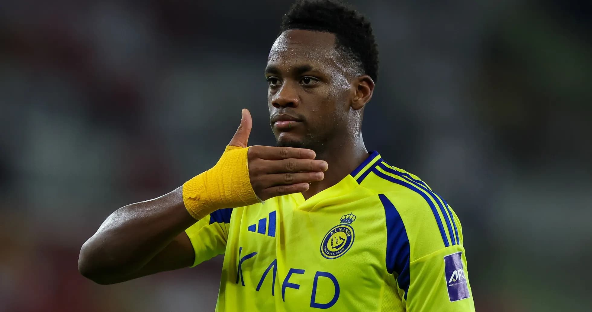 Player signaling during a football match in yellow jersey Player signaling during a football match in yellow jersey