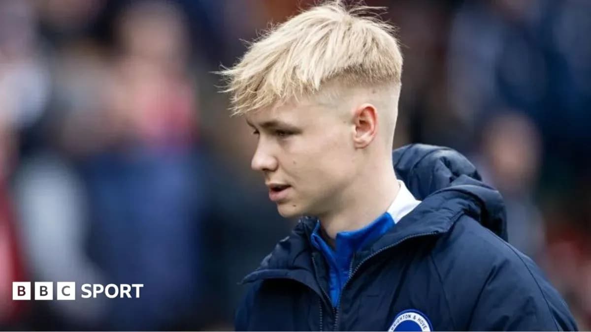 Player in team jacket walking on the sidelines Player in team jacket walking on the sidelines