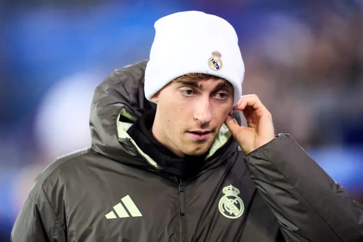 Player in Real Madrid jacket and beanie on pitch Player in Real Madrid jacket and beanie on pitch