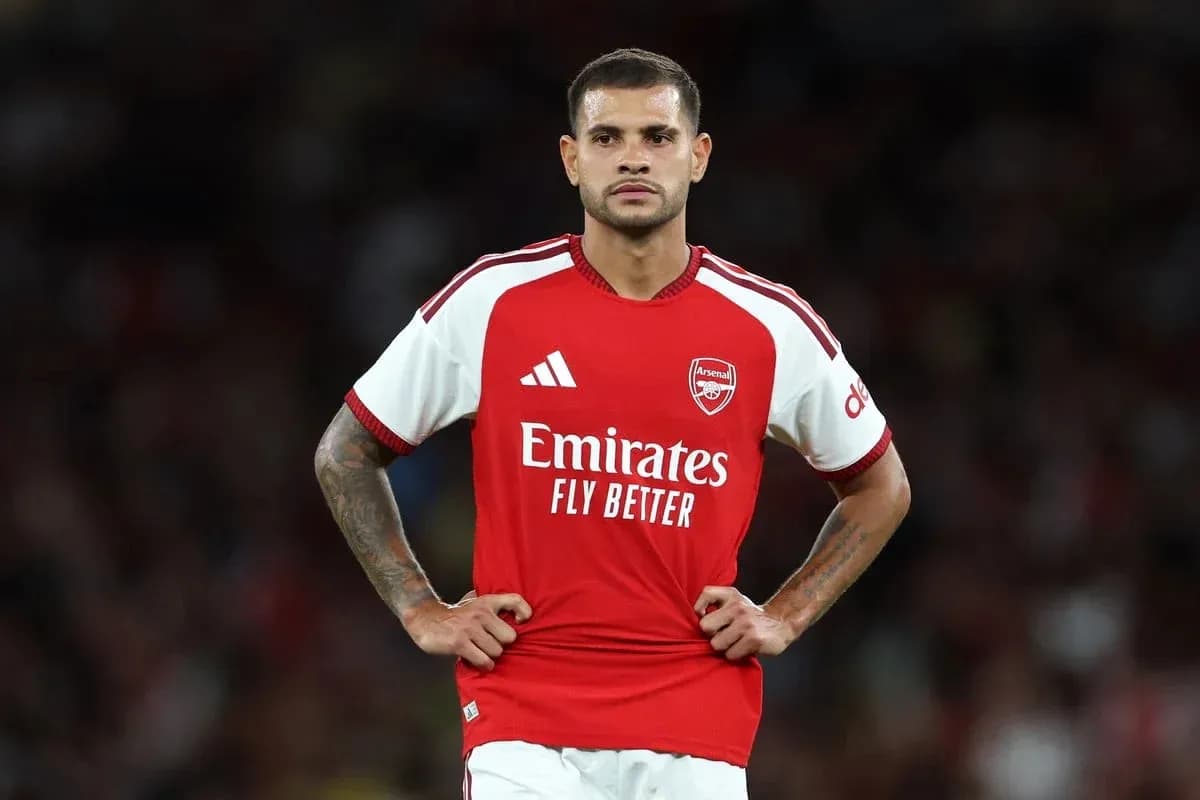 Player in Arsenal jersey standing on field Player in Arsenal jersey standing on field