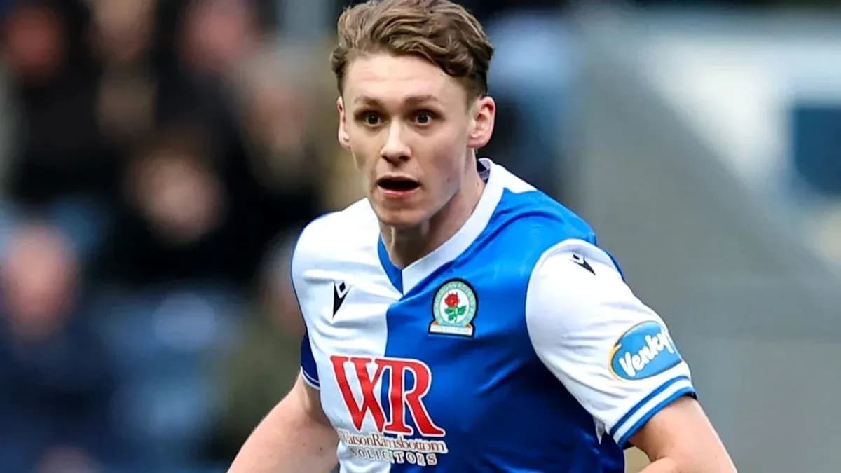 Player in Blackburn Rovers kit running on pitch Player in Blackburn Rovers kit running on pitch