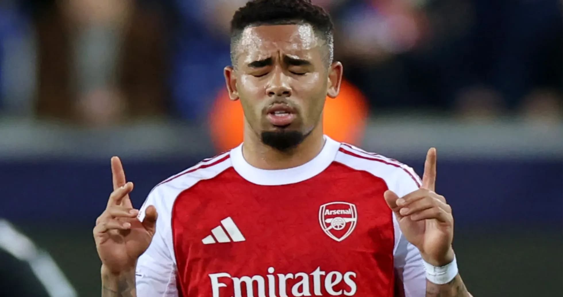 Player with Arsenal jersey praying on the field Player with Arsenal jersey praying on the field