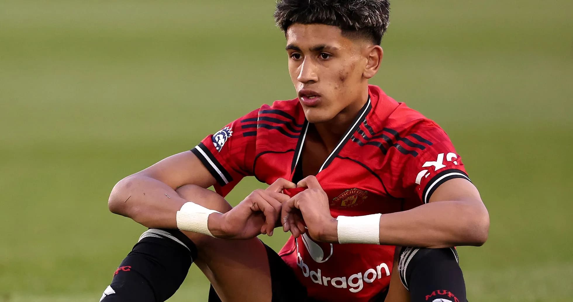 Player sitting on the pitch in Manchester United kit Player sitting on the pitch in Manchester United kit