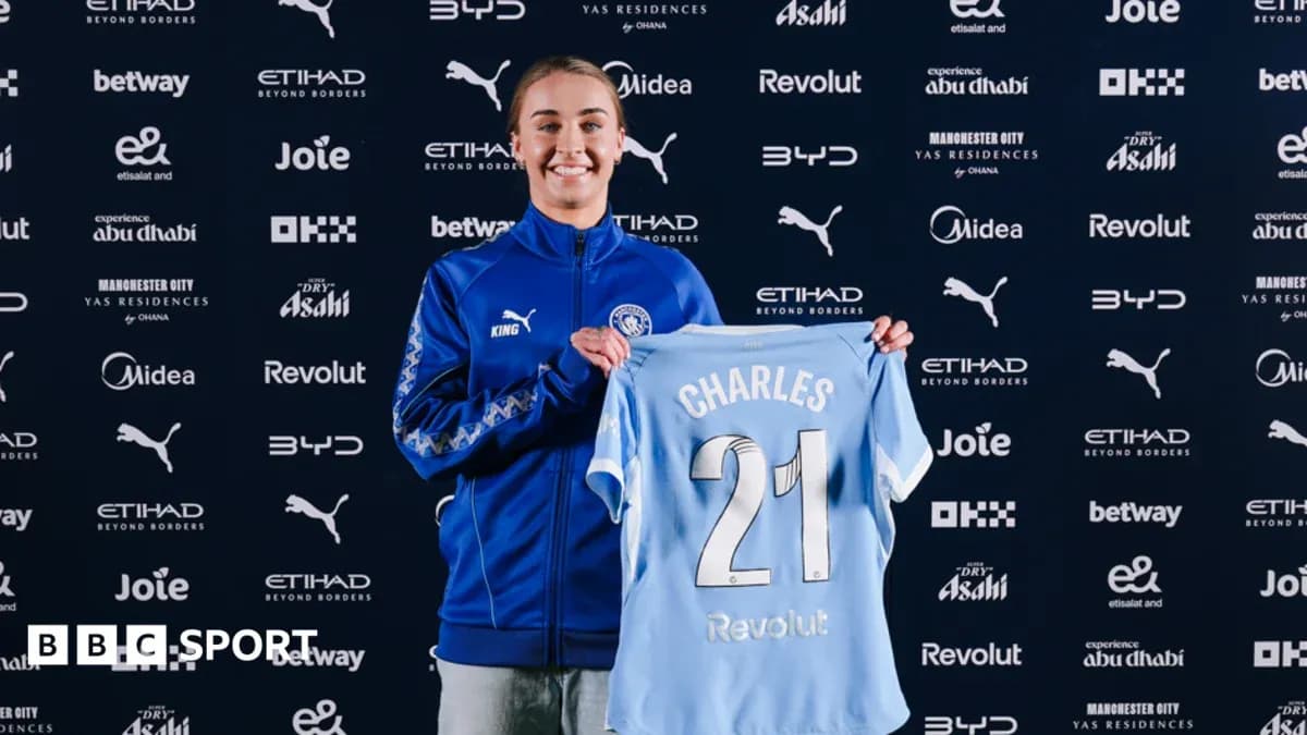 Player holding Manchester City jersey at announcement event Player holding Manchester City jersey at announcement event