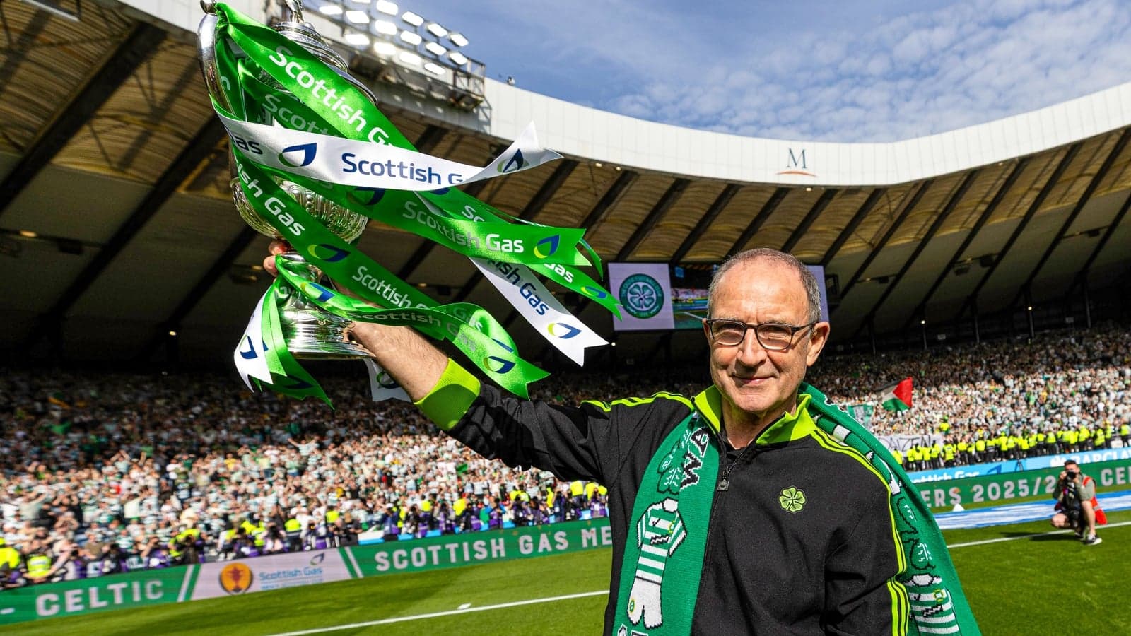 Man holding trophy with green ribbons at stadium Man holding trophy with green ribbons at stadium