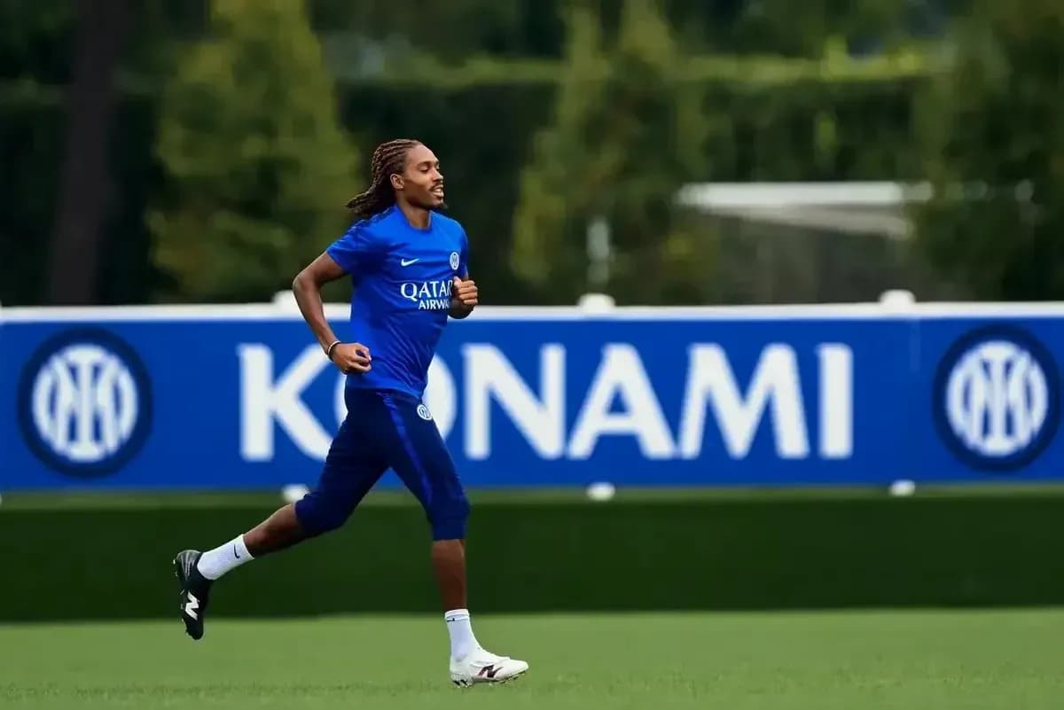 Player jogging on training pitch with team logo Player jogging on training pitch with team logo