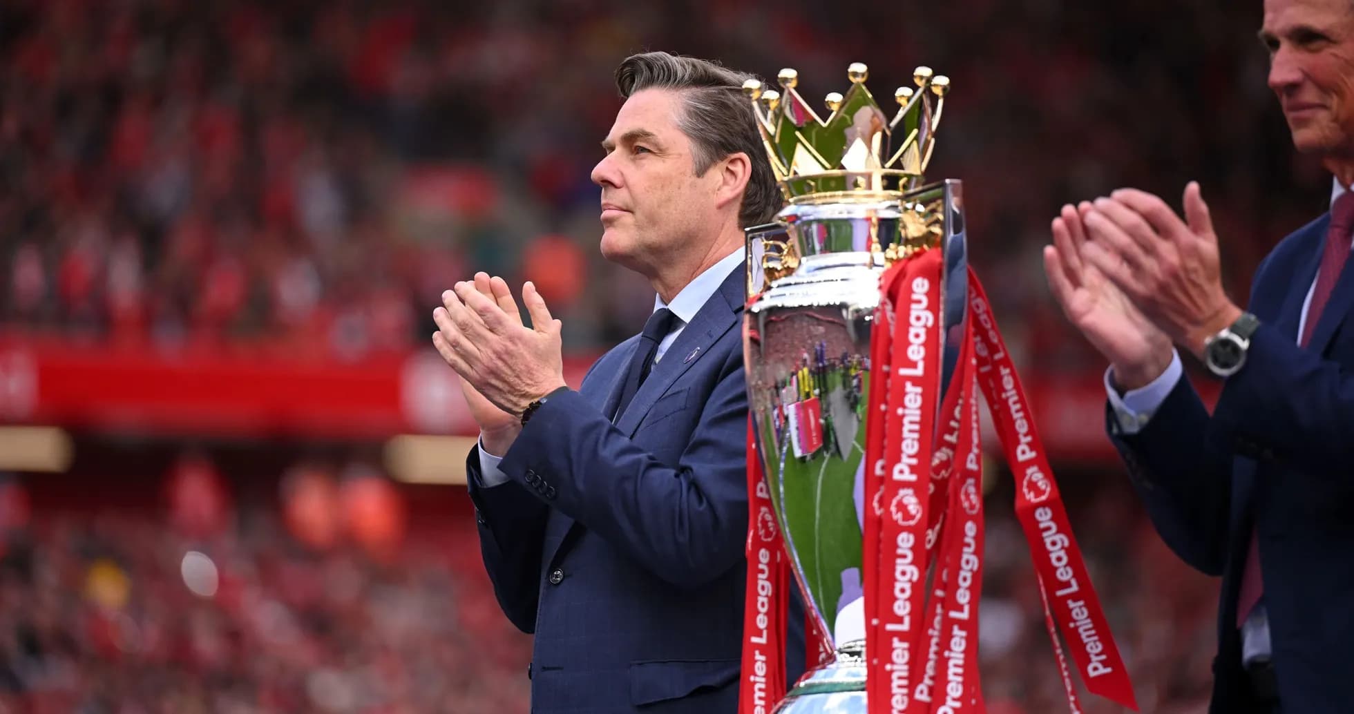 Man applauding next to Premier League trophy Man applauding next to Premier League trophy