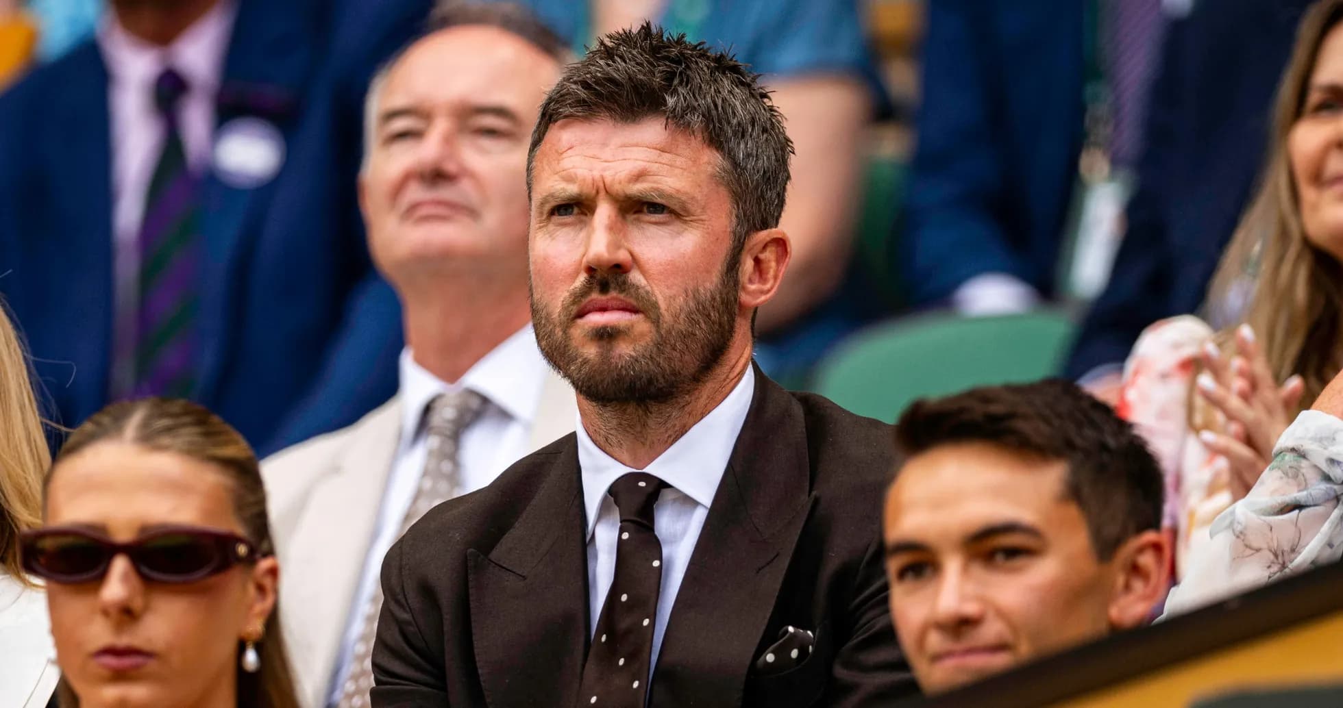 Man in suit watching tennis match in crowd Man in suit watching tennis match in crowd
