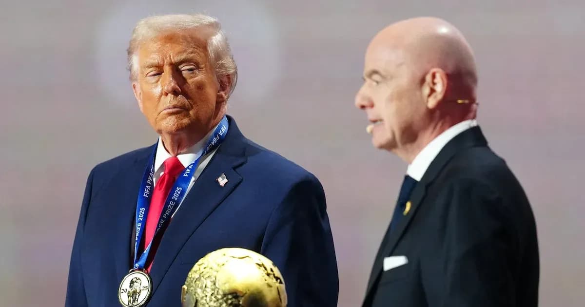 Man holding FIFA award with another speaker nearby Man holding FIFA award with another speaker nearby
