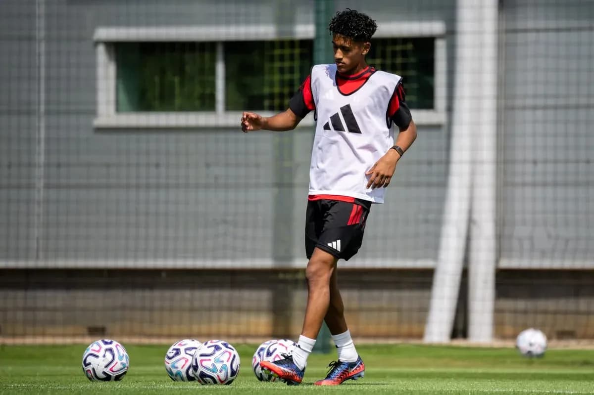 Player training on pitch with footballs nearby Player training on pitch with footballs nearby