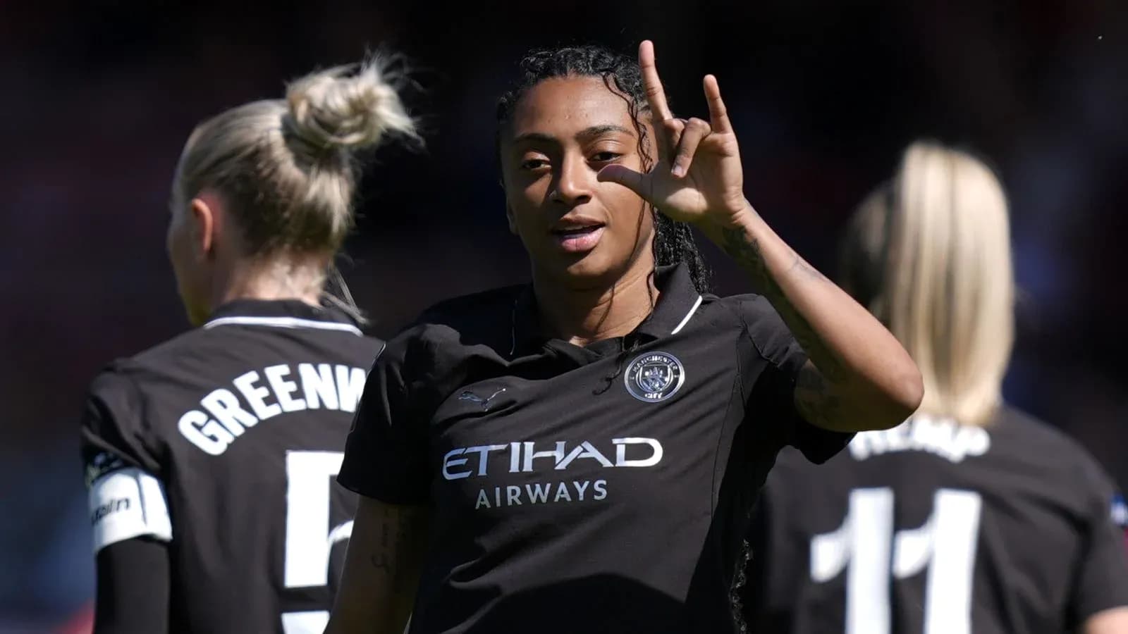 Player gesturing during match with teammates in background Player gesturing during match with teammates in background
