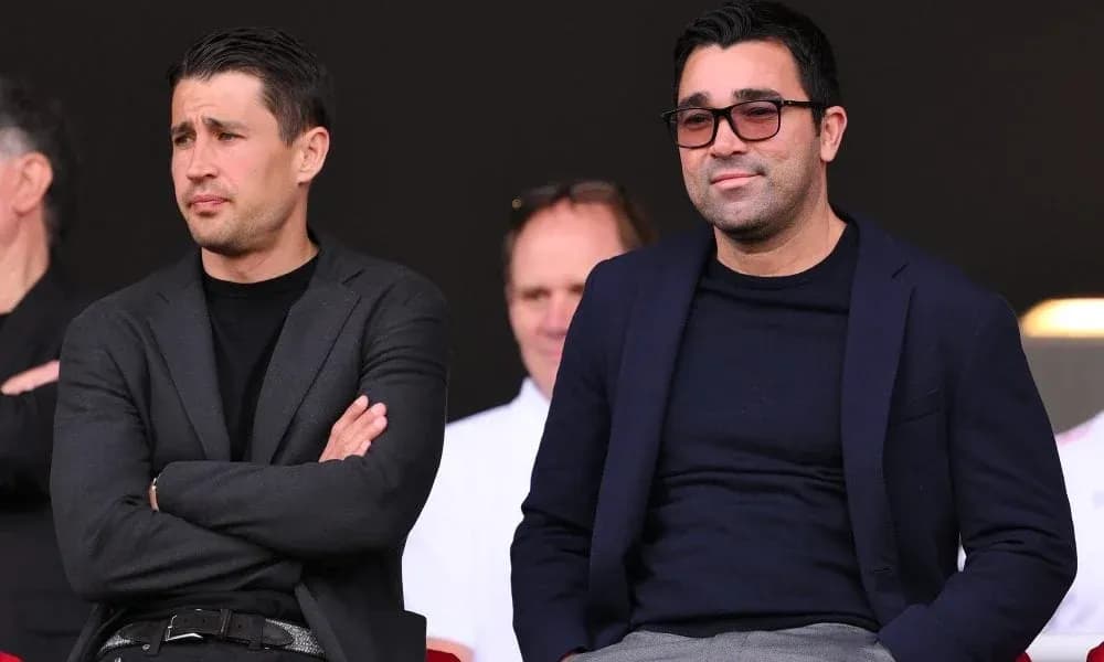 Two men seated in a stadium viewing area Two men seated in a stadium viewing area
