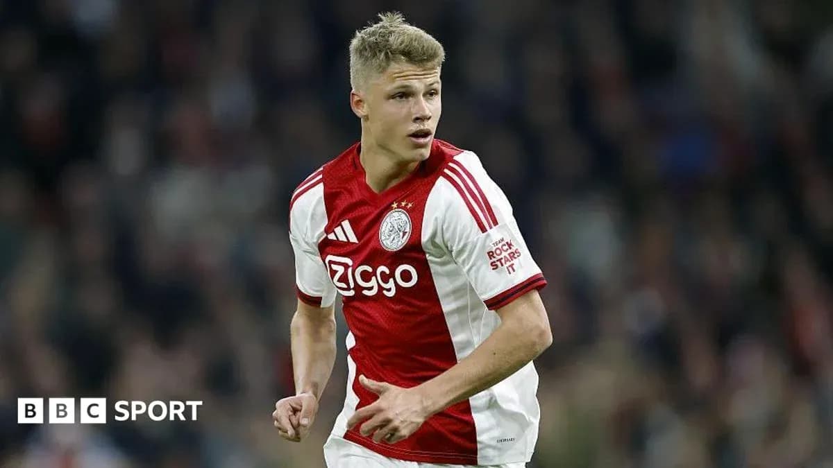 Player in Ajax kit running on the field Player in Ajax kit running on the field