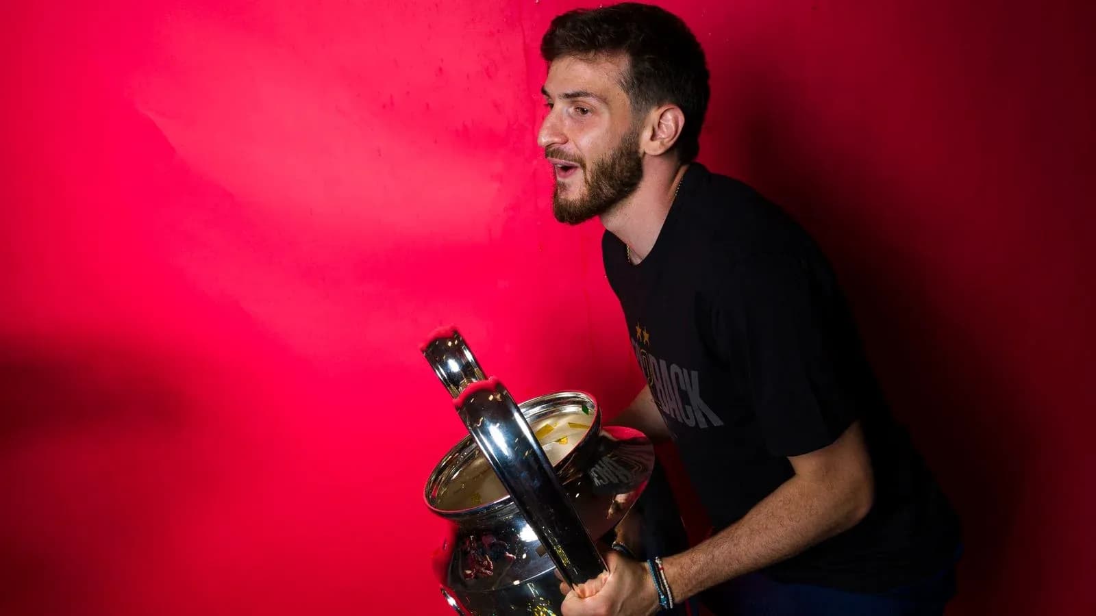 Player posing with trophy against pink background Player posing with trophy against pink background
