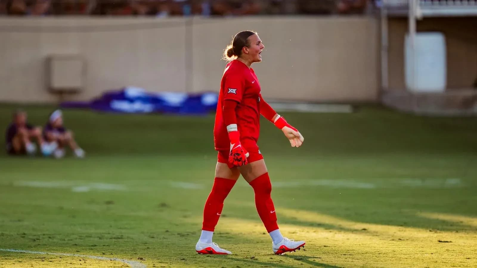 Goalkeeper in red kit celebrating on the field Goalkeeper in red kit celebrating on the field
