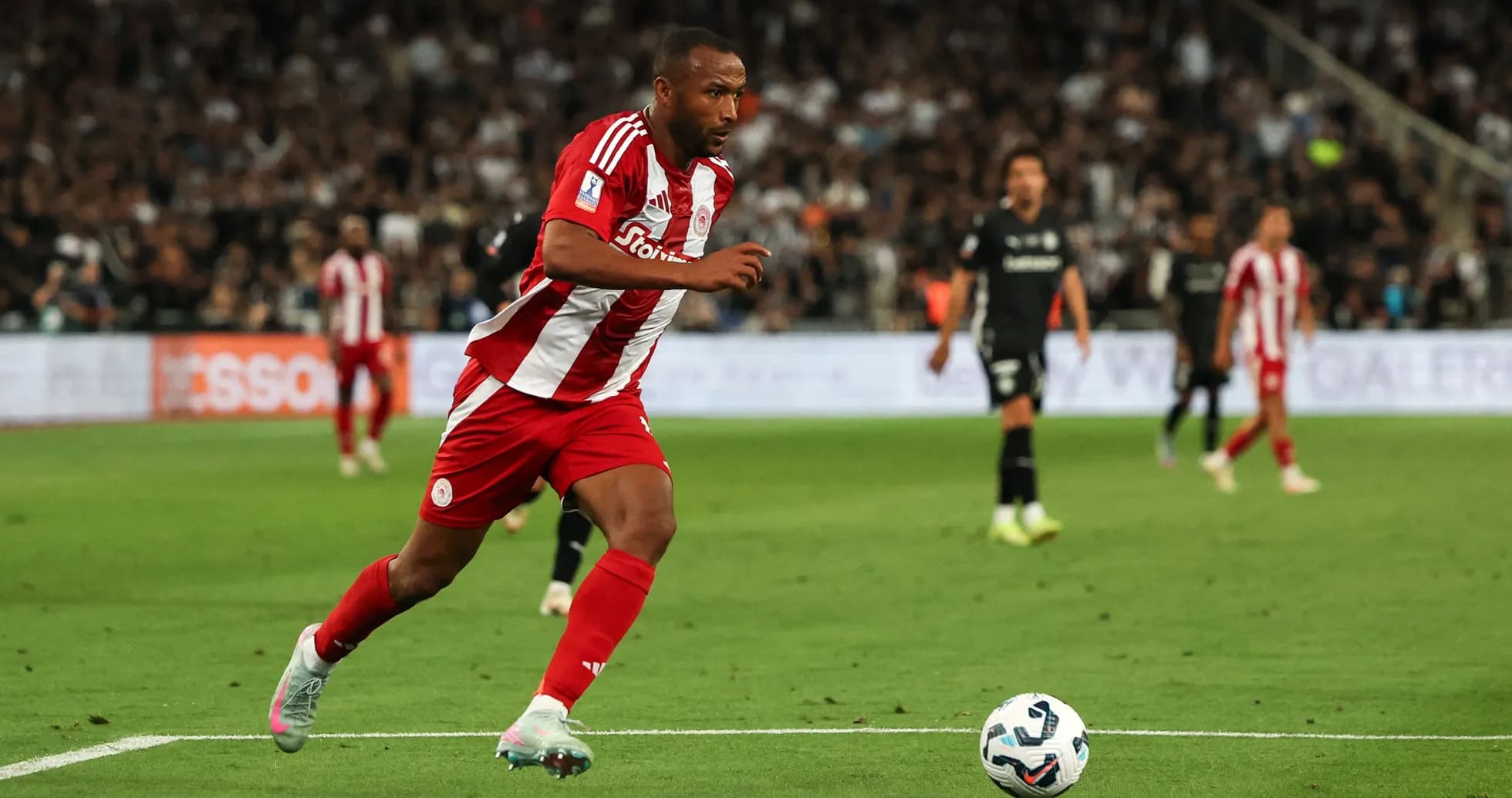 Player in red and white sprinting on the pitch Player in red and white sprinting on the pitch