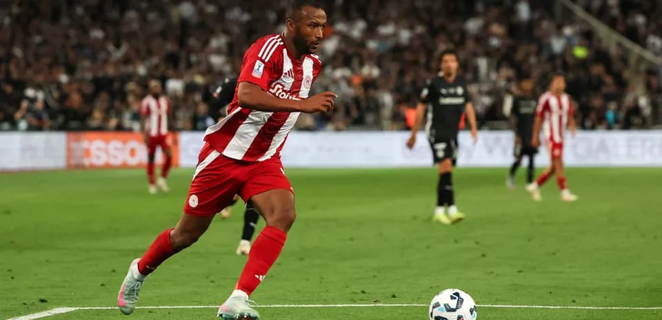 Player in red and white sprinting on the pitch Player in red and white sprinting on the pitch