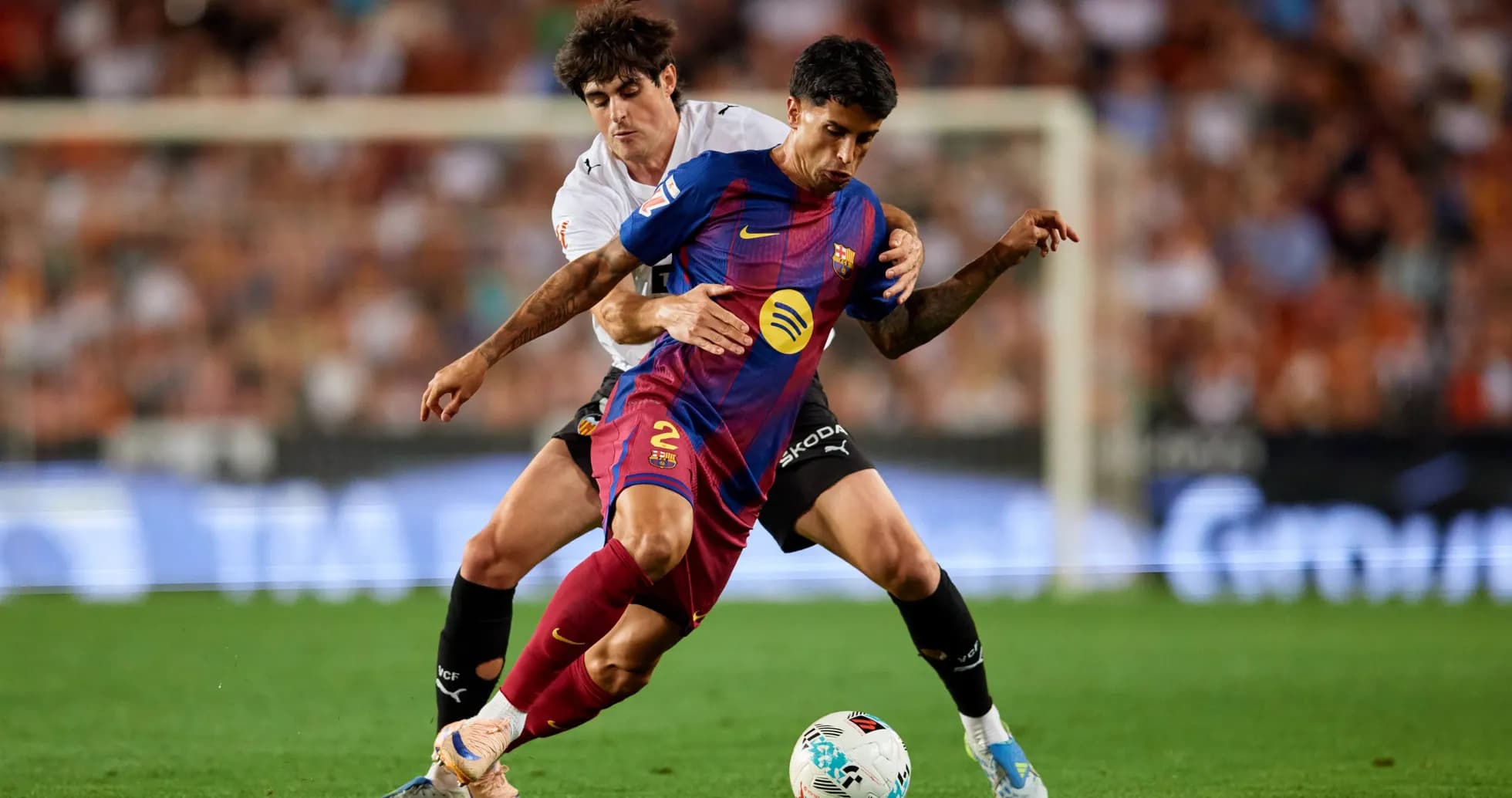 Barcelona player challenged by opponent during match Barcelona player challenged by opponent during match