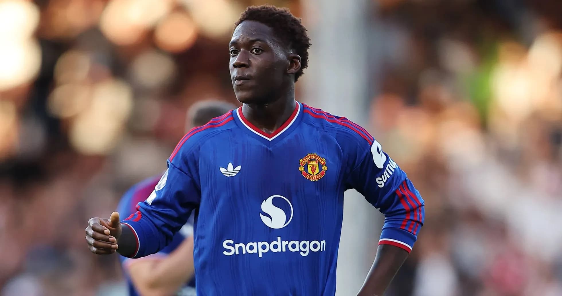 Player in blue Manchester United jersey on field Player in blue Manchester United jersey on field