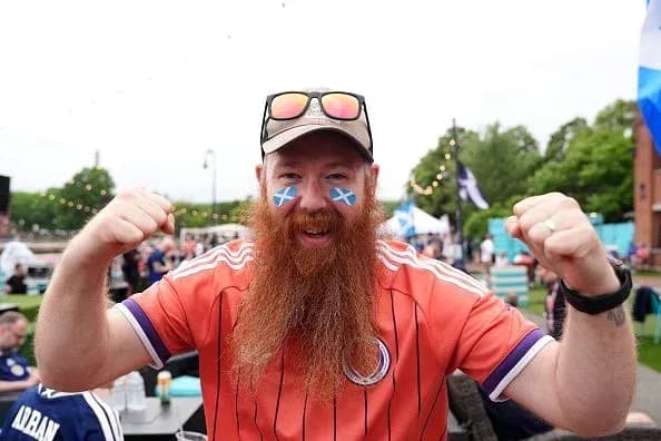 Fan celebrating with painted face and orange jersey Fan celebrating with painted face and orange jersey