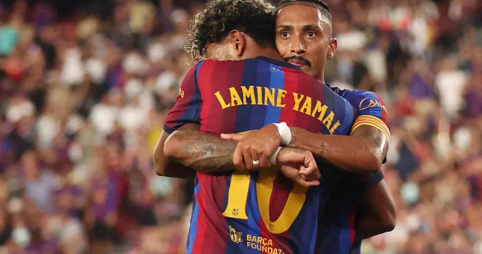 Two FC Barcelona players embracing on the pitch Two FC Barcelona players embracing on the pitch