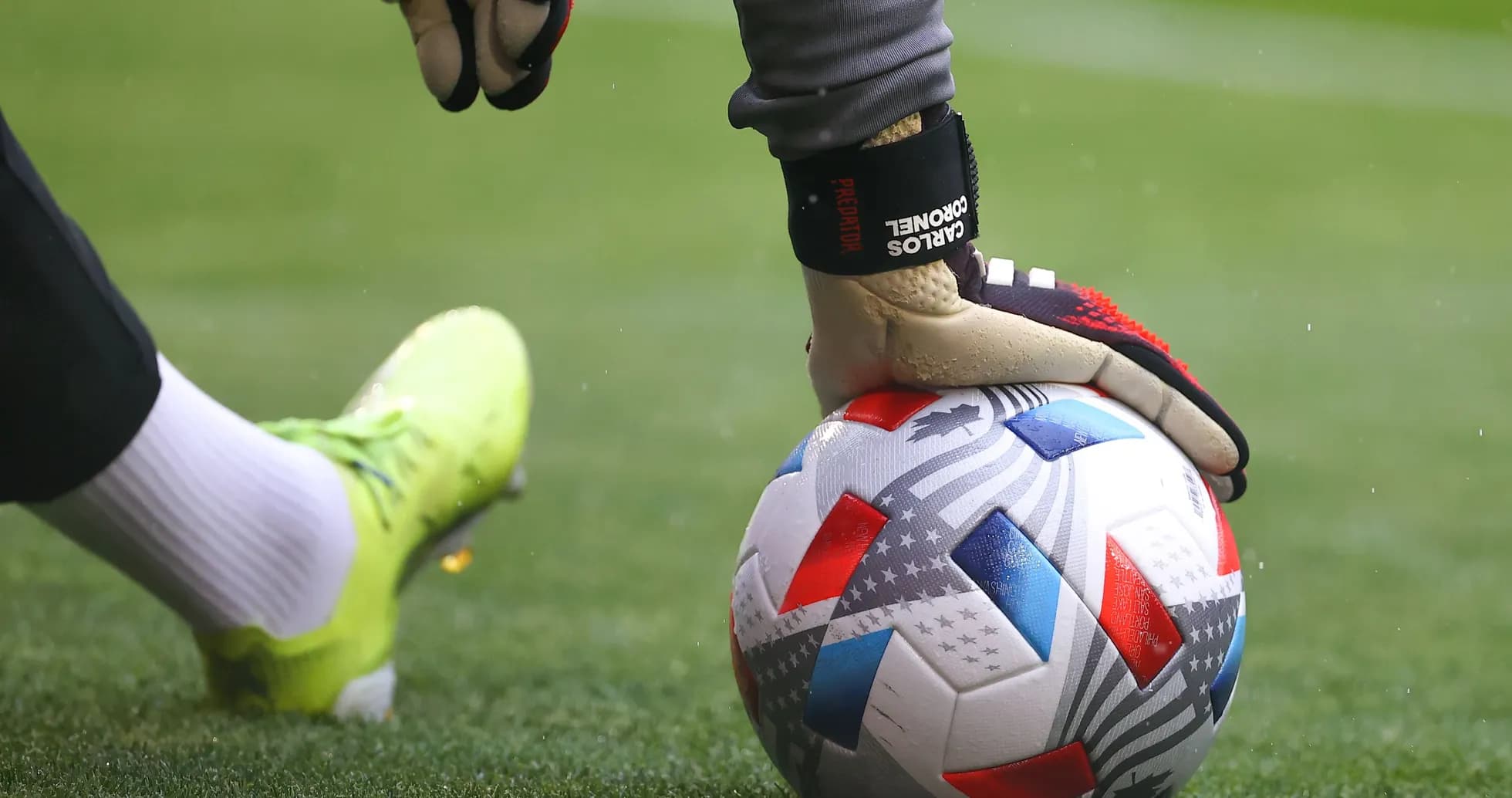 Goalkeeper placing hand on soccer ball on field Goalkeeper placing hand on soccer ball on field