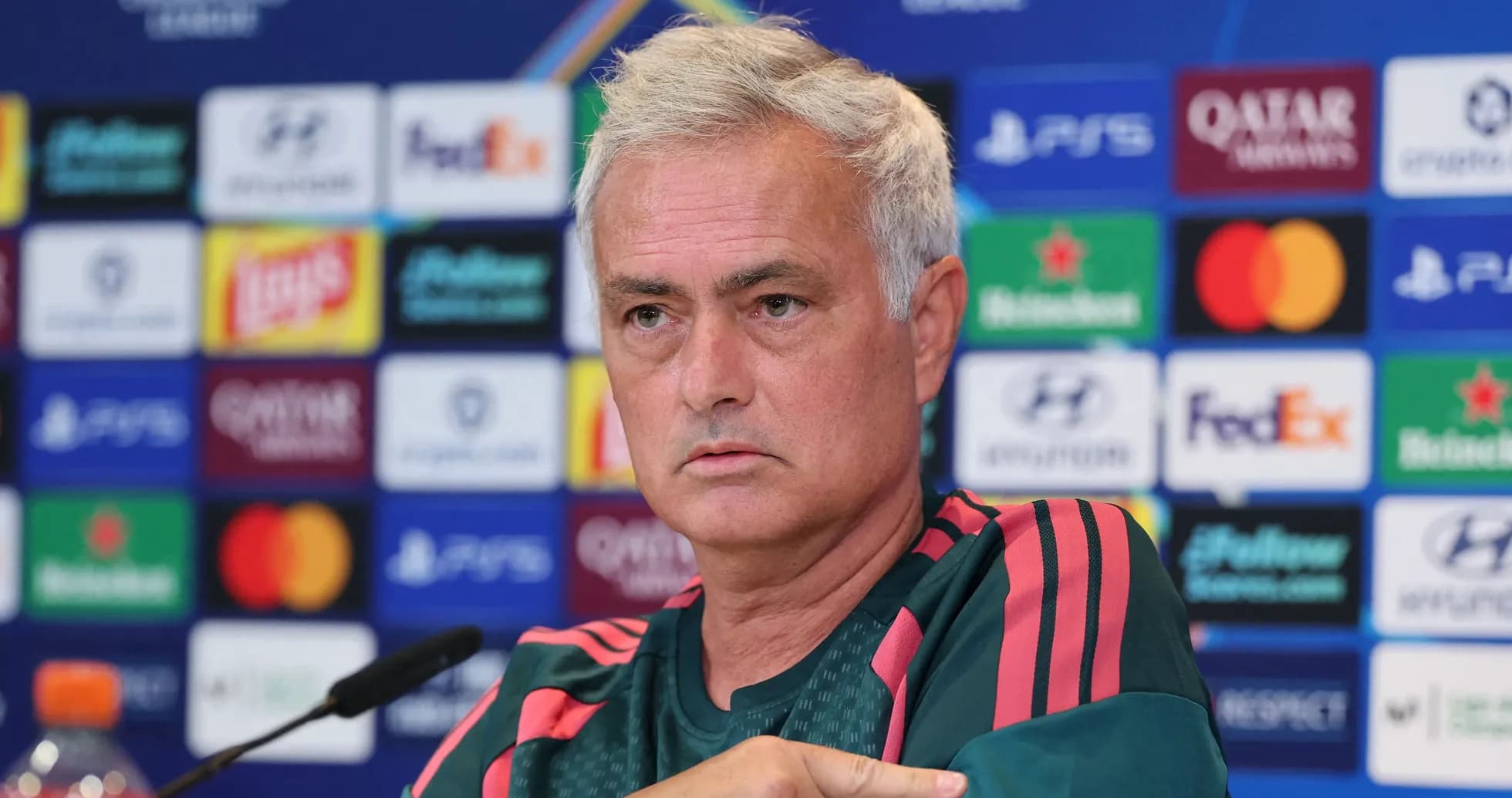 Manager speaking at press conference with logos in background Manager speaking at press conference with logos in background