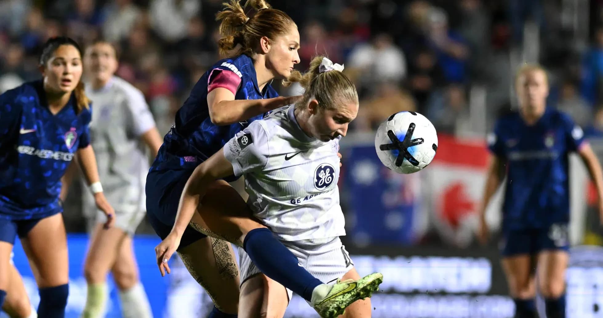 Players competing for the ball in NWSL match Players competing for the ball in NWSL match