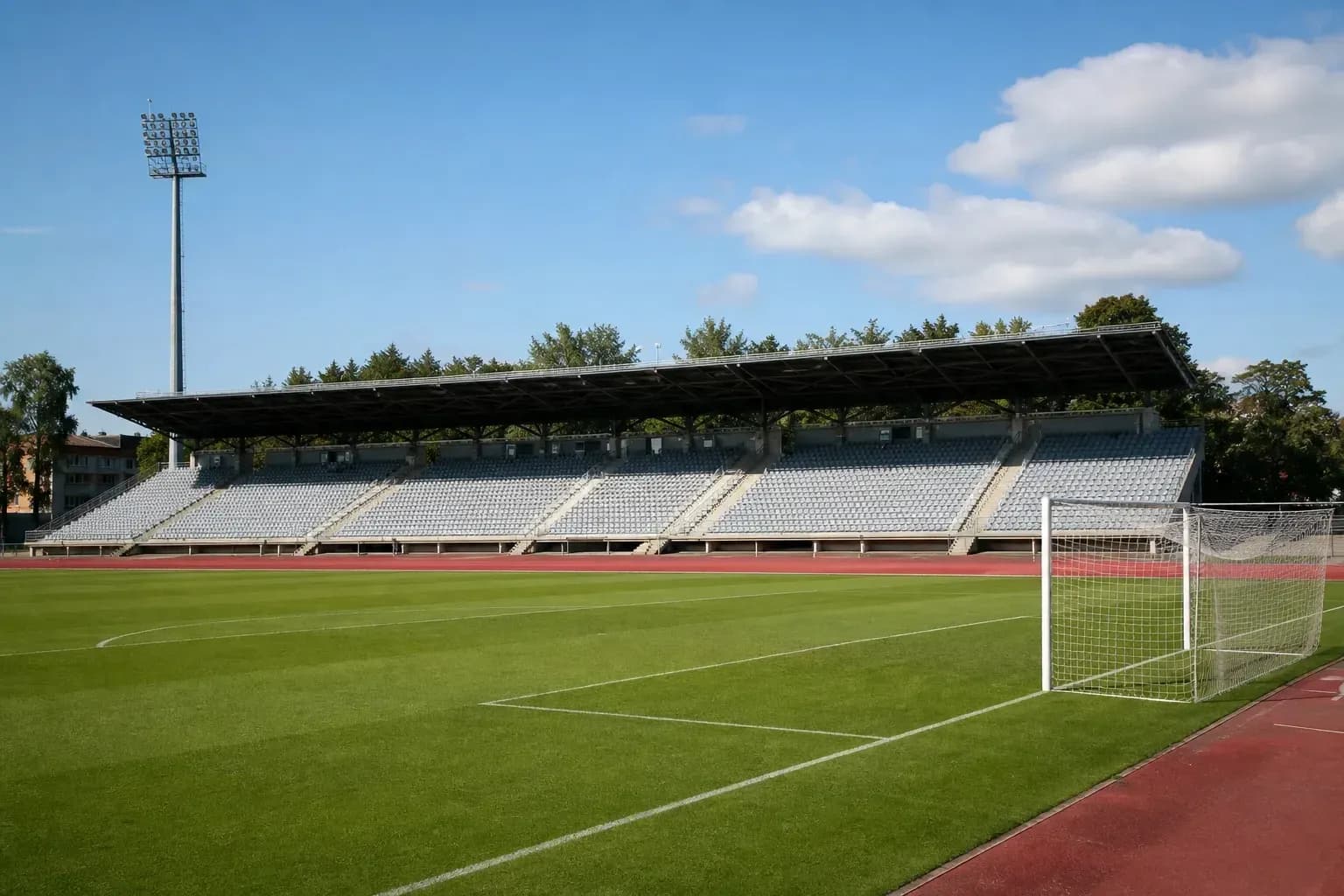 Empty football stadium with green pitch and stands Empty football stadium with green pitch and stands