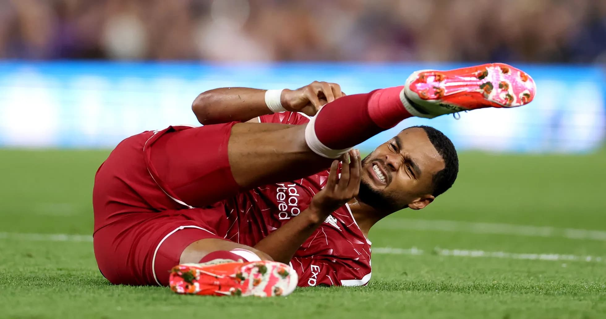 Player on the ground holding injured leg Player on the ground holding injured leg