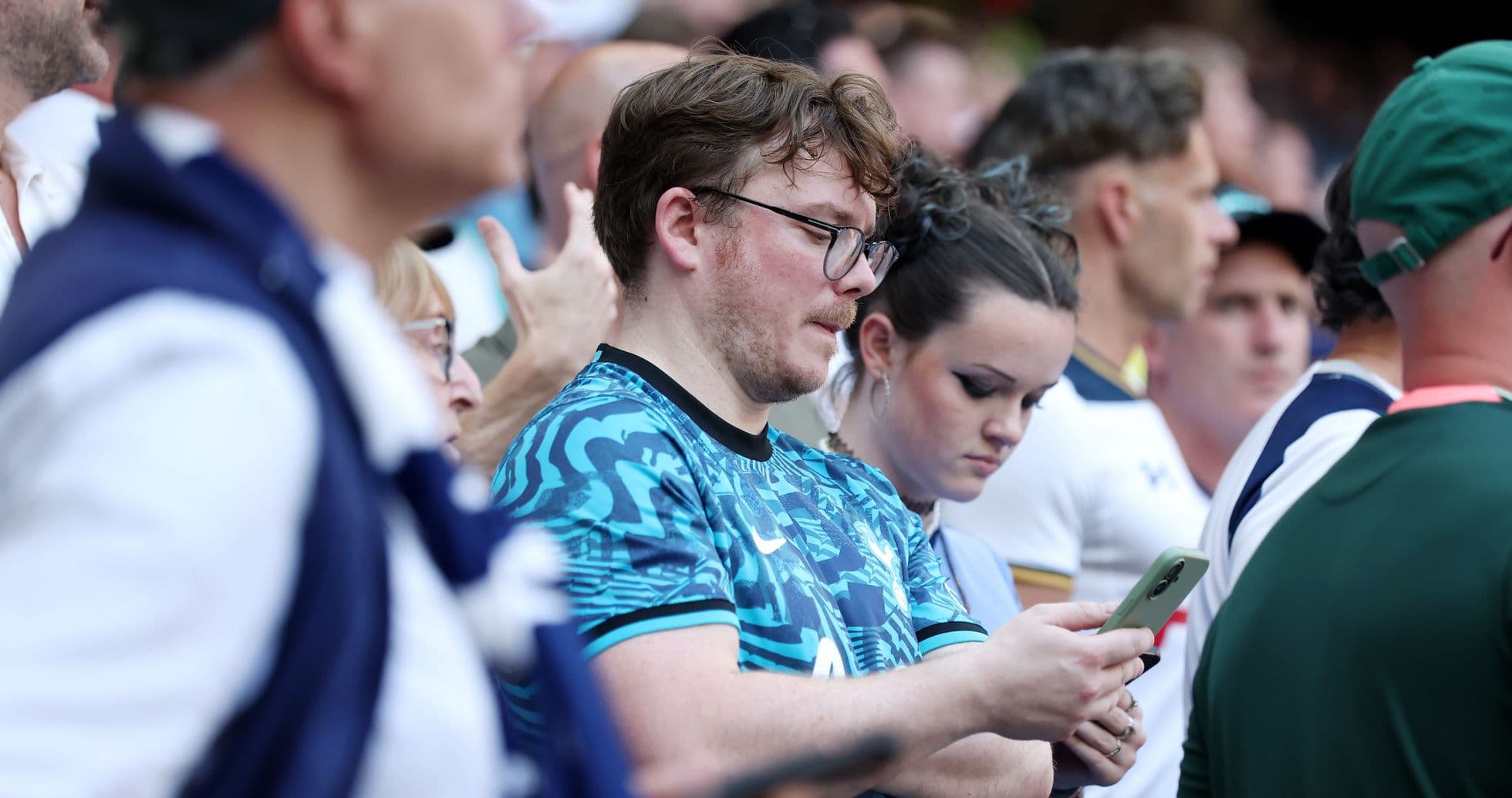 Fans in stadium looking at their phones Fans in stadium looking at their phones